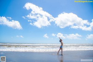 A woman in a bikini standing on a beach.