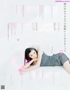 A woman in a pink top and blue jeans posing for a magazine.