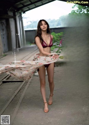 A woman in a maroon bikini posing for a picture.
