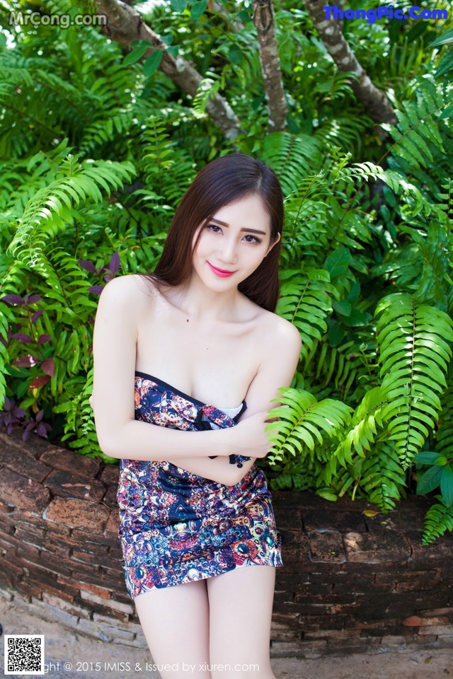 A woman in a blue and red dress posing for a picture.