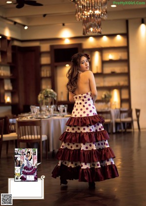 A woman in a white dress and pink high heels holding an apple.