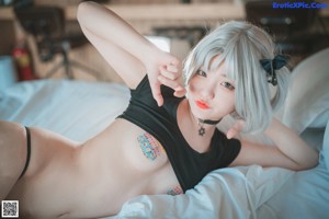 A woman in a black lingerie laying on a bed.
