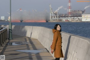 A young woman leaning against a wooden fence.