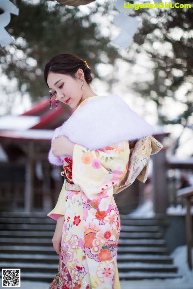 A woman in a kimono is standing in the snow.