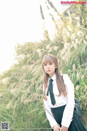 A woman in a school uniform posing for a picture.