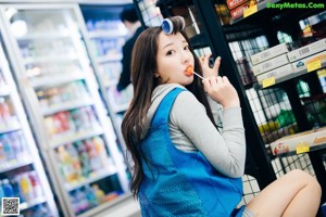 A woman in a blue jacket is standing in a store.