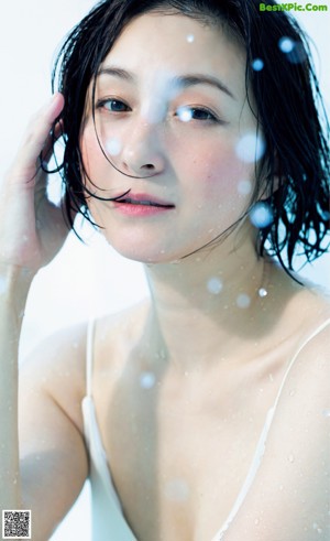 A woman in a white shirt and blue jeans posing for a magazine.
