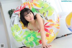 A woman in a bikini standing on an inflatable ring.