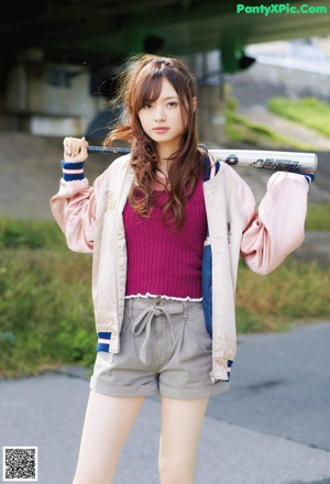 A woman in a pink tank top posing for a picture.