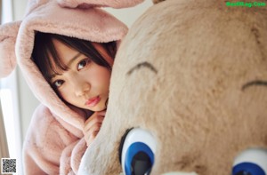 A woman laying on the floor next to a rabbit.