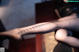 A woman sitting on a couch with her legs tied up.