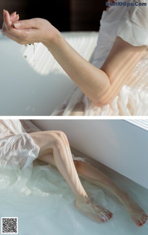 A woman sitting in a bathtub with her legs in the water.