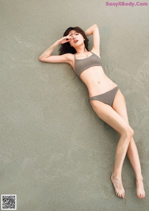 A woman in a long dress standing on a beach.