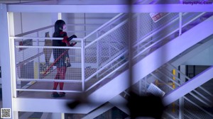 A woman in a red and black outfit holding two swords.