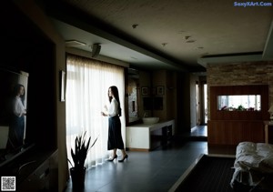 A woman in a white shirt and blue pleated skirt.